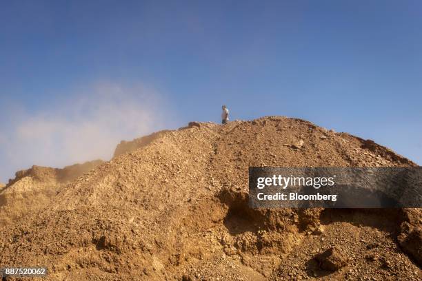 An employee stands atop a pile of clay in a preparation unit at the Shabbir Tiles & Ceramics Ltd. Production facility in Karachi, Pakistan, on...