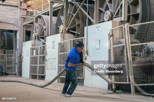An employee drags a hose through the ball mill department at the Shabbir Tiles & Ceramics Ltd. Production facility in Karachi, Pakistan, on...