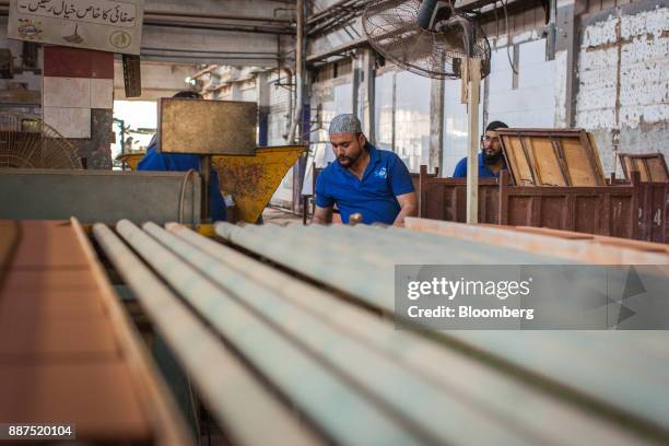 Employees watch unglazed tiles moving along a conveyor at the Shabbir Tiles & Ceramics Ltd. Production facility in Karachi, Pakistan, on Wednesday,...