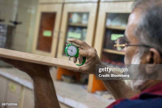 An employee examines a sample tile in the laboratory at the Shabbir Tiles & Ceramics Ltd. Production facility in Karachi, Pakistan, on Wednesday,...