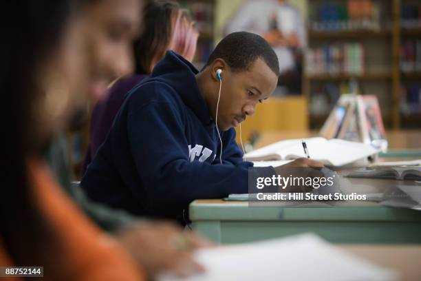 teenage boy studying in school library - writing music stock pictures, royalty-free photos & images