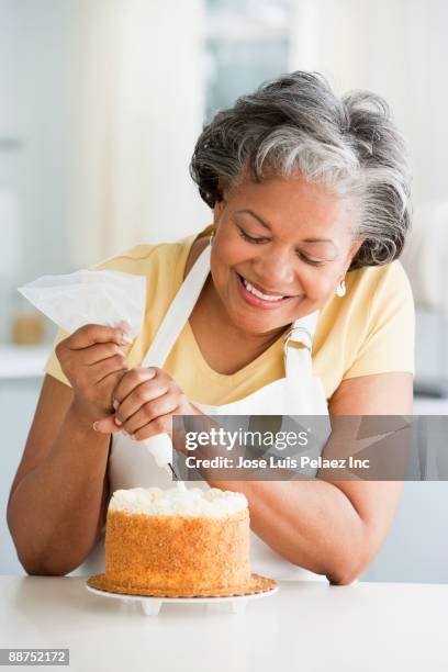 african woman decorating cake - kuchen dekorieren stock-fotos und bilder