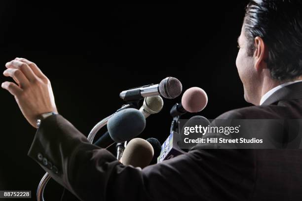 hispanic man at press conference microphones - politician back stock pictures, royalty-free photos & images