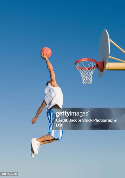 man playing basketball outdoors - basketball player dunk stock pictures, royalty-free photos & images