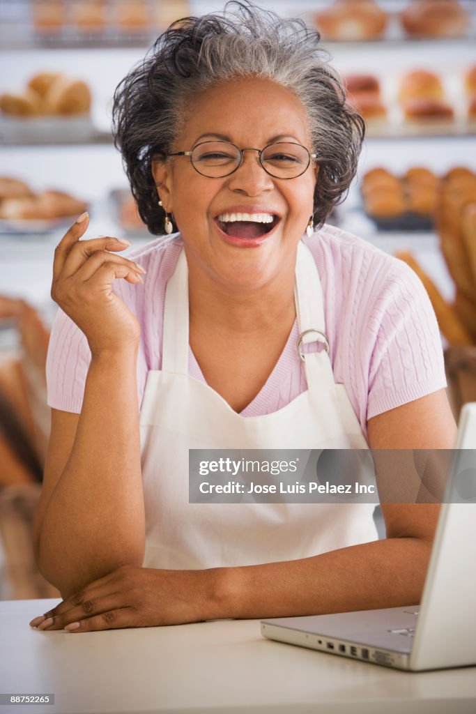 Laughing African woman behind counter in bakery