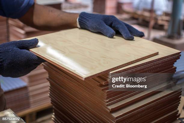 An employee arranges tiles before packing into the boxes at the Shabbir Tiles & Ceramics Ltd. Production facility in Karachi, Pakistan, on Wednesday,...