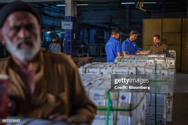 Employees count boxes of tiles before delivery to the warehouse at the Shabbir Tiles & Ceramics Ltd. Production facility in Karachi, Pakistan, on...