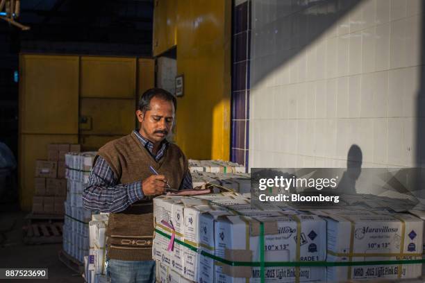 An employee counts boxes of tiles before delivery to the warehouse at the Shabbir Tiles & Ceramics Ltd. Production facility in Karachi, Pakistan, on...