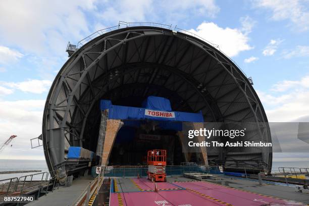 Media representatives walk on top of the No. 3 reactor building at the Fukushima Daiichi nuclear power plant where a huge dome is being constructed...