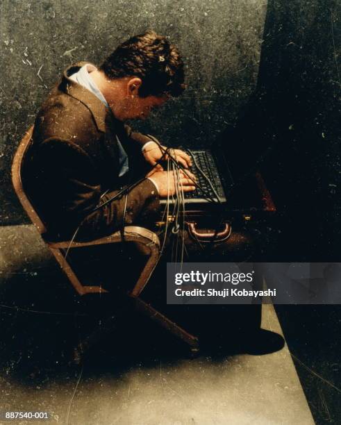 businessman strapped in chair with computer cables (distressed) - man tied to chair stockfoto's en -beelden