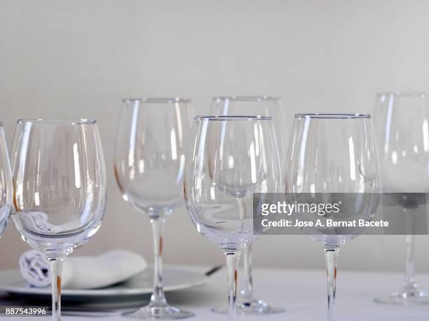 restaurant table prepared with white tablecloth, napkins, cutlery and wine glasses, with wooden chairs on a white background - la belle équipe restaurant stock pictures, royalty-free photos & images