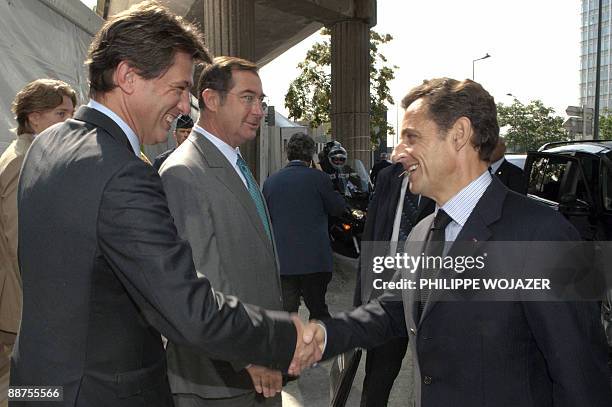 France's President Nicolas Sarkozy shakes hands with AXA's management board chairman Henri de Castries and Martin Bouygues , head of French builder...