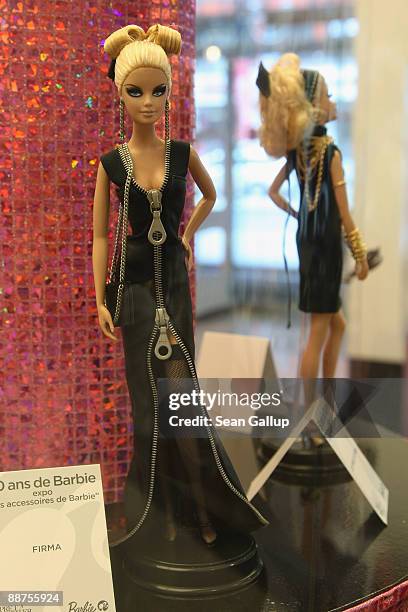 Barbie dolls in outfits by fashion designers stand on display at the "Barbie And Her Accessoires" exihibit, which marks 50 years of Barbie, at the...