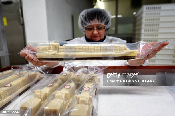 An employee arranges container ships made of fresh marzipan at the headquarters of the traditional confectionary maker JG Niederegger GmbH in...