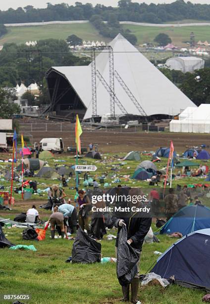 Litter picker, one of the 600 who were signed on to start today, picks up some rubbish on the start of the big clear up of the Glastonbury Festival...