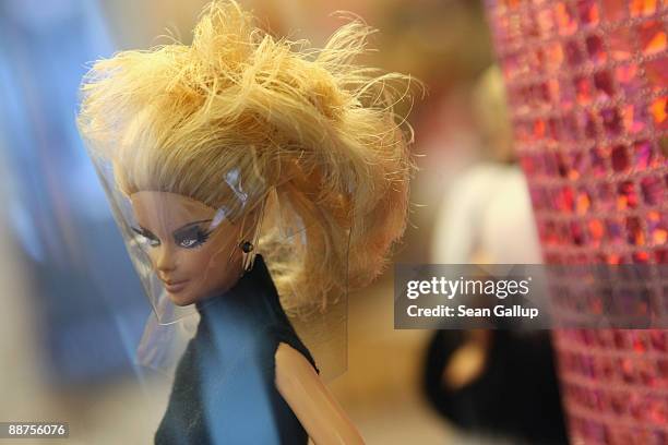 Coiffed Barbie doll stands on display at the "Barbie And Her Accessoires" exhibit, which marks 50 years of Barbie, at the Galeries Lafayette on June...