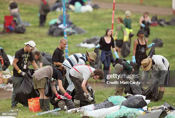 Litter-pickers, some of the 600 who were signed on to start today, pick up some of the rubbish on the start of the big clear-up of the Glastonbury...