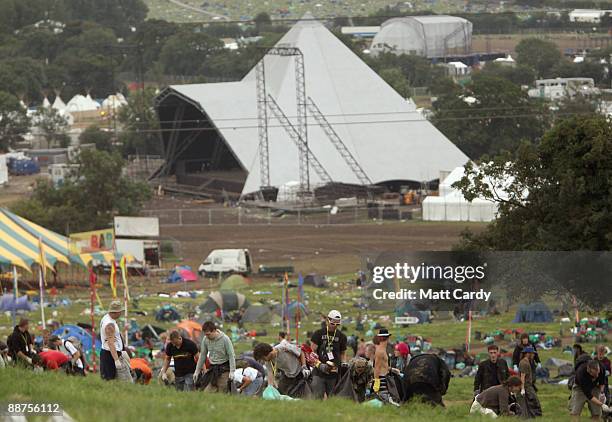 Litter-pickers, some of the 600 who were signed on to start today, pick up some of the rubbish on the start of the big clear-up of the Glastonbury...