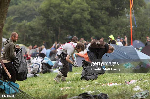 Litter-pickers, some of the 600 who were signed on to start today, pick up some of the rubbish on the start of the big clear-up of the Glastonbury...