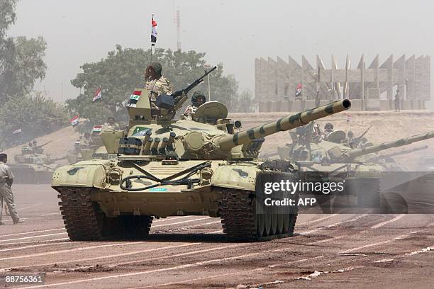 Iraqi T-72 tanks roll towards the "Tomb of the Unknown Soldier" in the secure "Green Zone" during a parade in central Baghdad on June 30 to mark the...