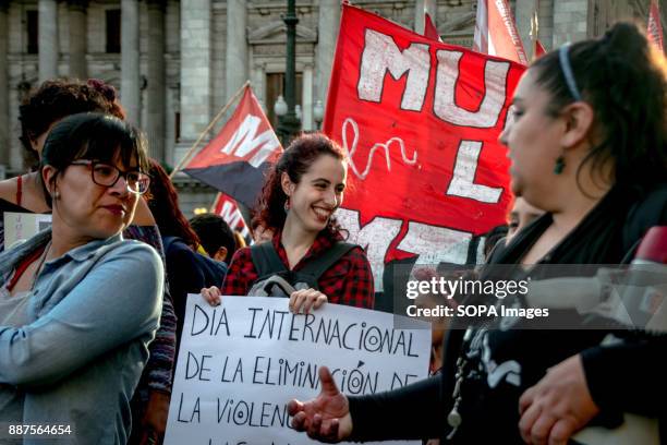 Smiling, a protestor holds a sign calling for the elimination of violence against women. Marching from the nation's iconic Congreso buildings to...