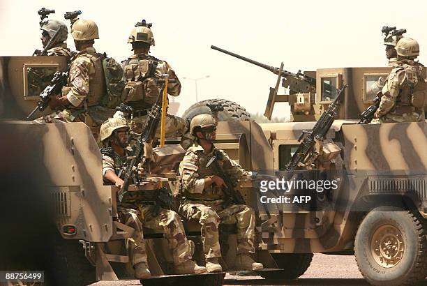 Soldiers ride on the back of armoured vehicles during a parade past the "Tomb of the Unknown Soldier" in the secure "Green Zone" in central Baghdad...