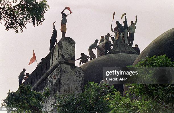 In this file photograph taken on December 6, 1992 Hindu youths clamour atop the 16th century Muslim Babri Mosque five hours before the structure was...