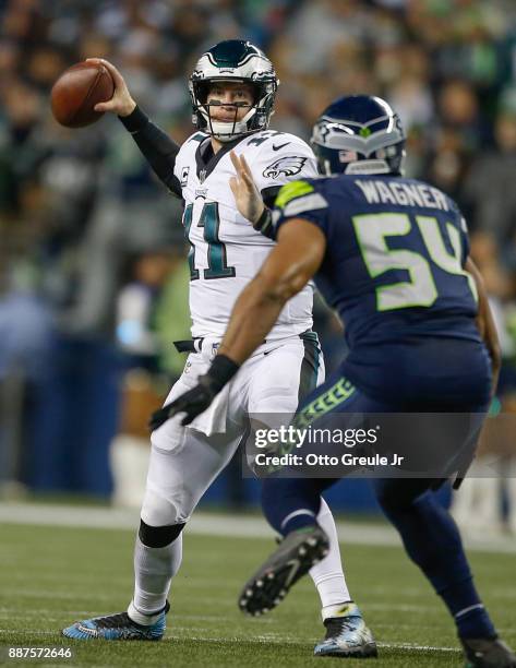 Quarterback Carson Wentz of the Philadelphia Eagles looks to pass under pressure from middle linebacker Bobby Wagner of the Seattle Seahawks in the...