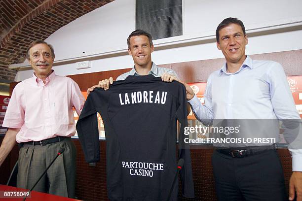 Lille's new goalkeeper Mickael Landreau poses presents his new jersey next to Lille's president Michel Seydou and Lille's coach Rudi Garcia during...