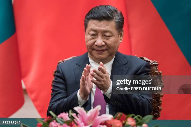 China's President Xi Jinping applauds during a signing ceremony with Maldives' President Abdulla Yameen at the Great Hall of the People in Beijing on...