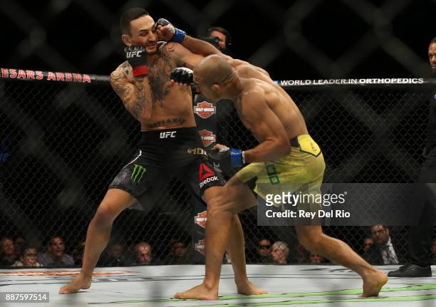 Jose Aldo punches Max Holloway during the UFC 218 event at Little Caesars Arena on December 2, 2017 in Detroit, Michigan.