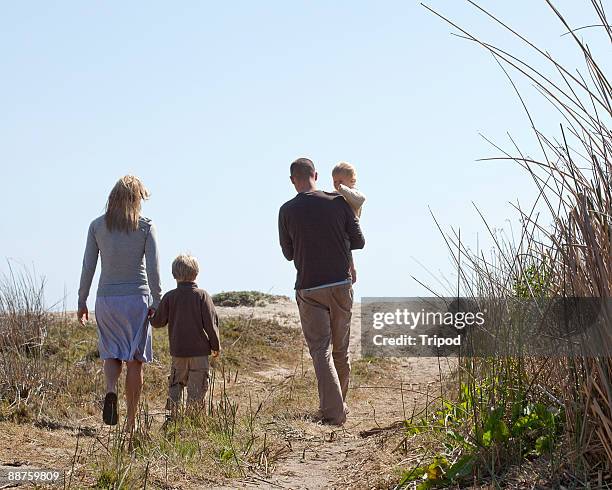 family of four walking down path outdoors - the way forward stock-fotos und bilder