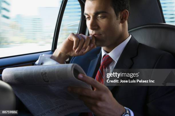 hispanic businessman reading newspaper in limousine - newspaper luxury bildbanksfoton och bilder