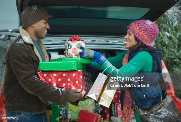 couple unloading christmas presents from car trunk - car grill stock pictures, royalty-free photos & images