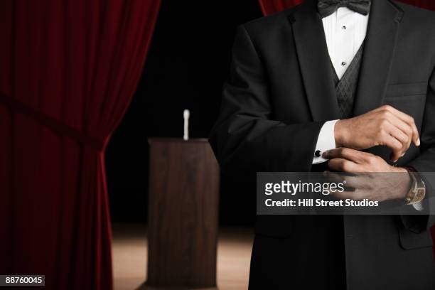 african american man in tuxedo adjusting cufflinks backstage - dinner jacket man stock pictures, royalty-free photos & images