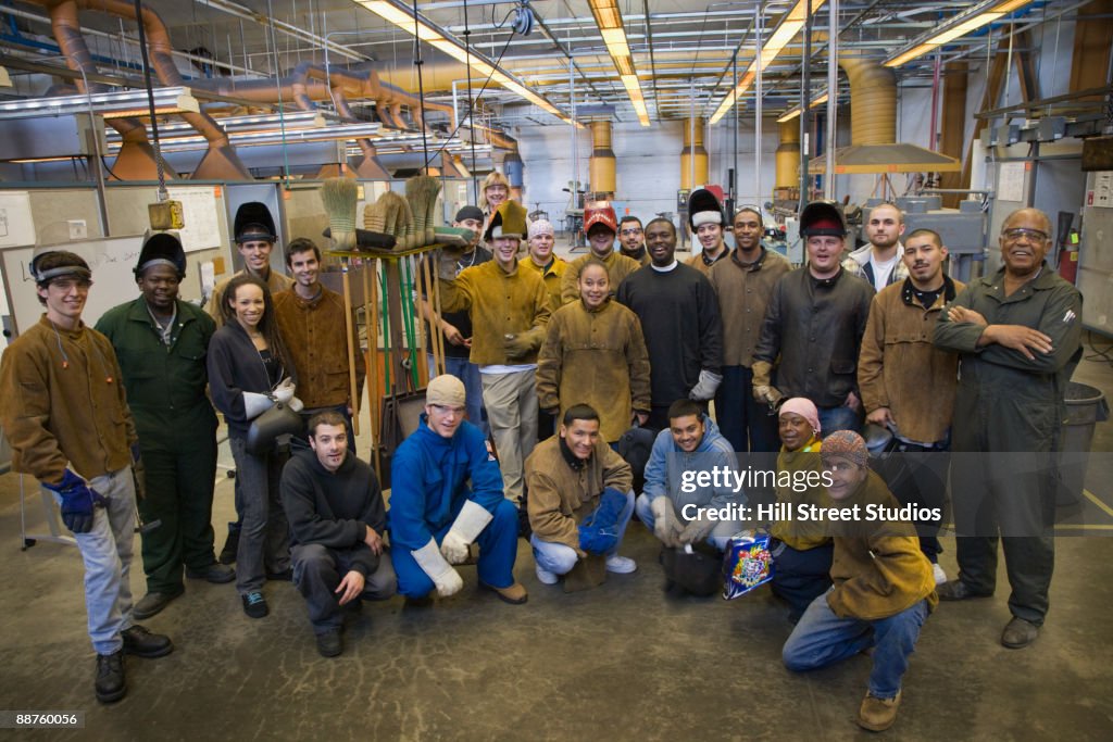 Large group of welders posing in foundry