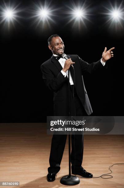 african american man in tuxedo onstage with microphone - dj portrait stock pictures, royalty-free photos & images