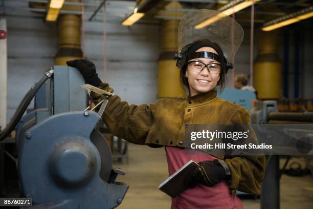 mixed race female welder posing by equipment - metal worker stock pictures, royalty-free photos & images