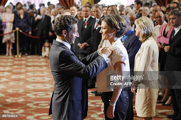 French president Nicolas Sarkozy awards French deputy minister for Ecology Chantal Jouanno chevalier de l'Ordre national du Merite on June 30, 2009...