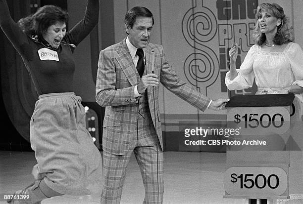 Contestant named Barbara leaps for joy, while host Bob Barker and model Janice Pennington share the stage, on 'The Price Is Right', February 1978.