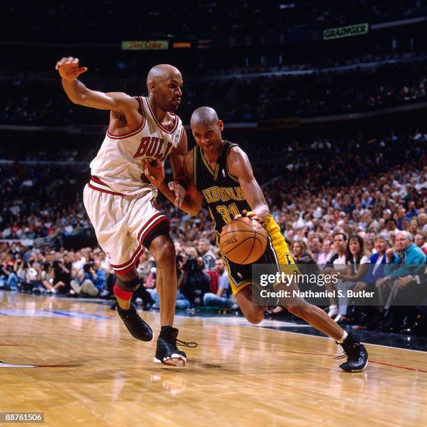 Reggie Miller of the Indiana Pacers drives to the basket against Ron Harper of the Chicago Bulls in Game Two of the Eastern Conference Finals during...