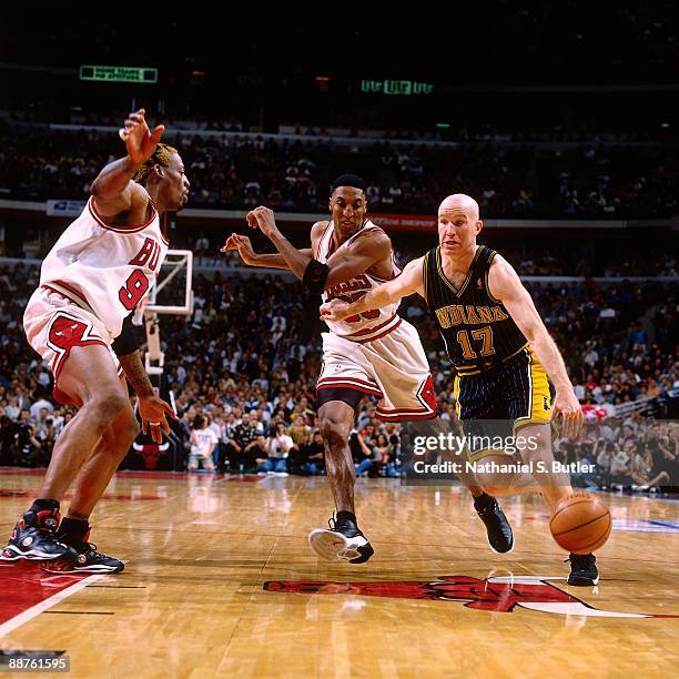 Chris Mullin of the Indiana Pacers drives to the basket against Dennis Rodman and Scottie Pippen of the Chicago Bulls in Game Two of the Eastern...