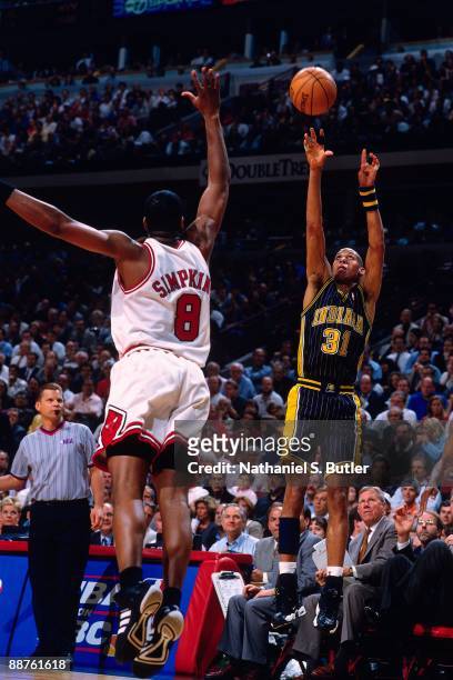 Reggie Miller of the Indiana Pacers shoots a jump shot against Dickey Simpkins of the Chicago Bulls in Game Five of the Eastern Conference Finals...