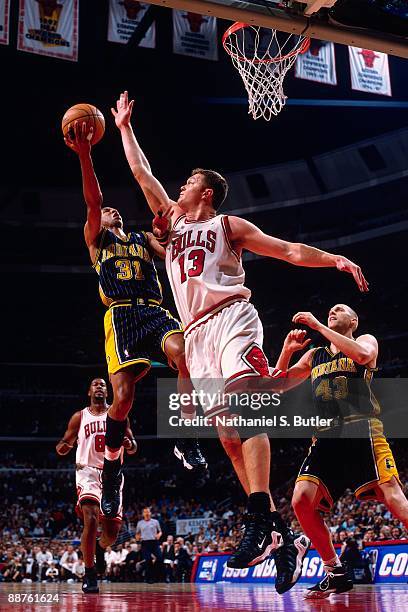 Reggie Miller of the Indiana Pacers shoots a layup against Luc Longley of the Chicago Bulls in Game Five of the Eastern Conference Finals during the...