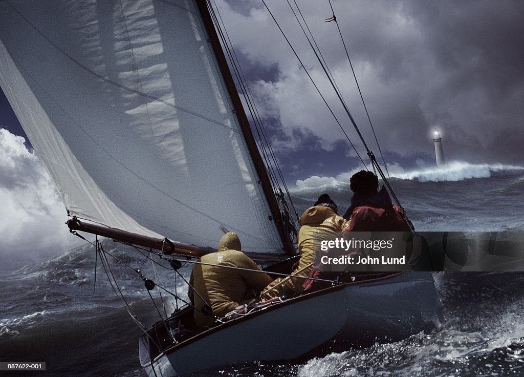 Sailboat in stormy seas, lighthouse in distance (Digital Composite)