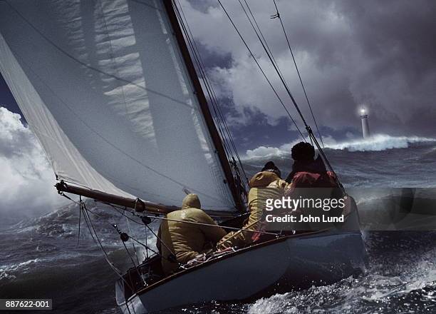 sailboat in stormy seas, lighthouse in distance (digital composite) - gray boot stockfoto's en -beelden