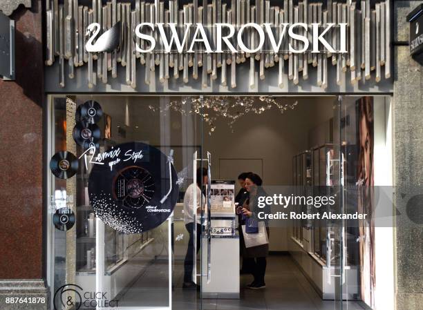 Customers shop at a Swarovski jewelry and decorative accessories shop in London, England.