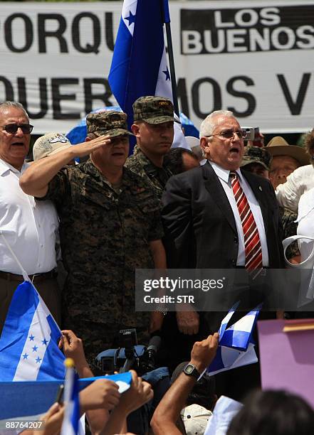 Honduran interim President Roberto Micheletti , standing next to the country's top military chief, General Romeo Vasquez , delivers a speech to...