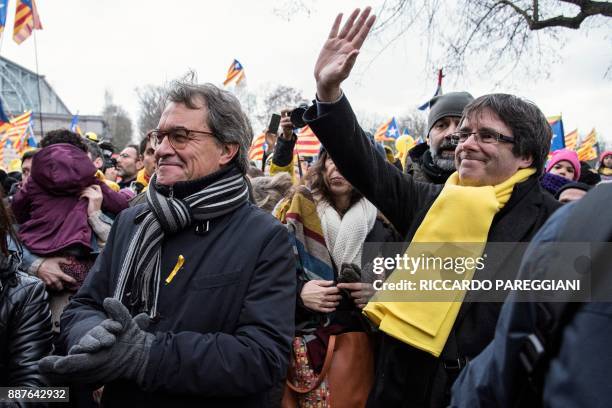 Catalonia's deposed regional president Carles Puigdemont and Former Catalan regional president Artur Mas wave to supporters during a pro-independence...