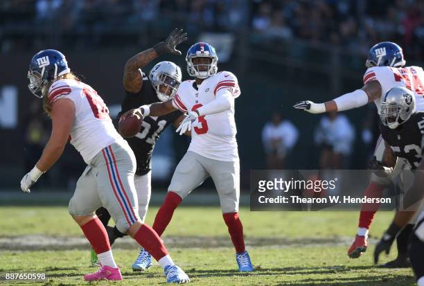 Bruce Irvin of the Oakland Raiders from behind puts pressure on quarterback Geno Smith of the New York Giants during their NFL football game at...